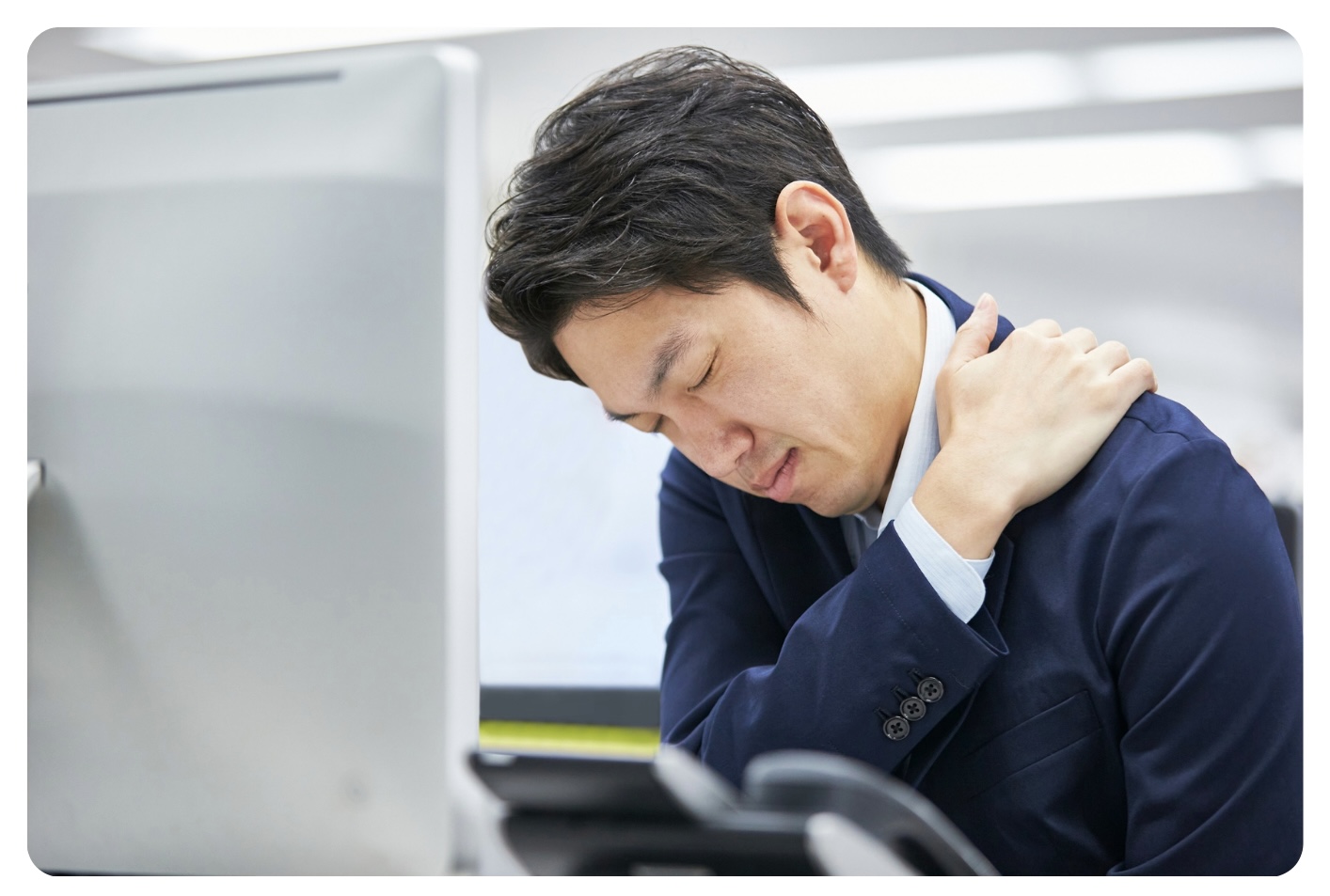 デスクワーク中に肩のつらさを感じるイメージ