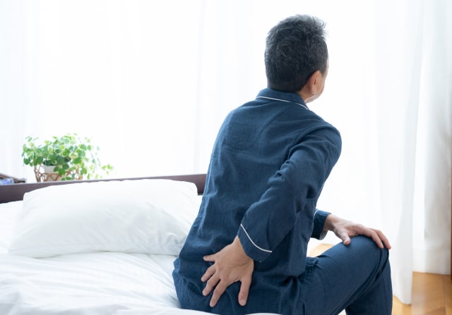 朝ベッドから起き上がる瞬間に腰が痛む様子